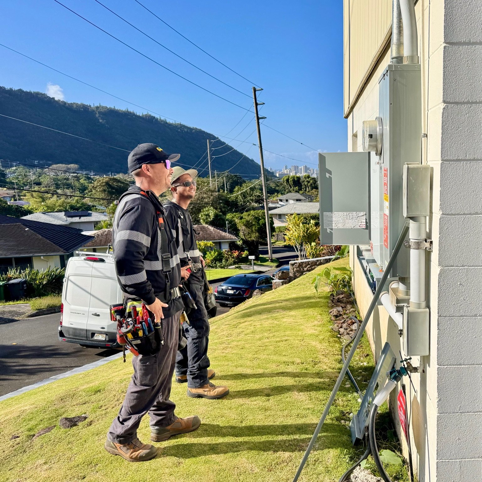 Electrical workers at an exterior electrical service panel